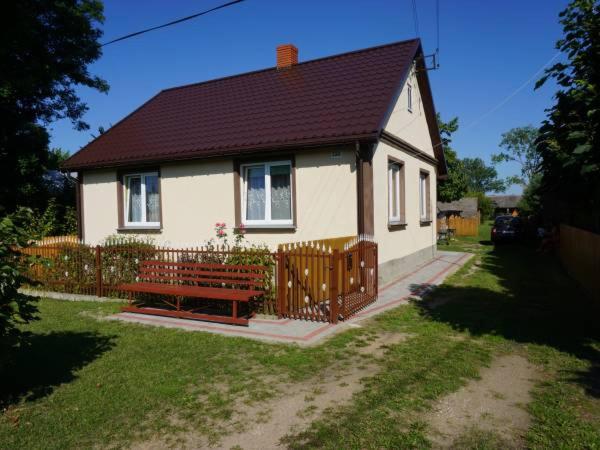 uma pequena casa com um banco à frente em Domek na wsi-agroturystyka em Czyże