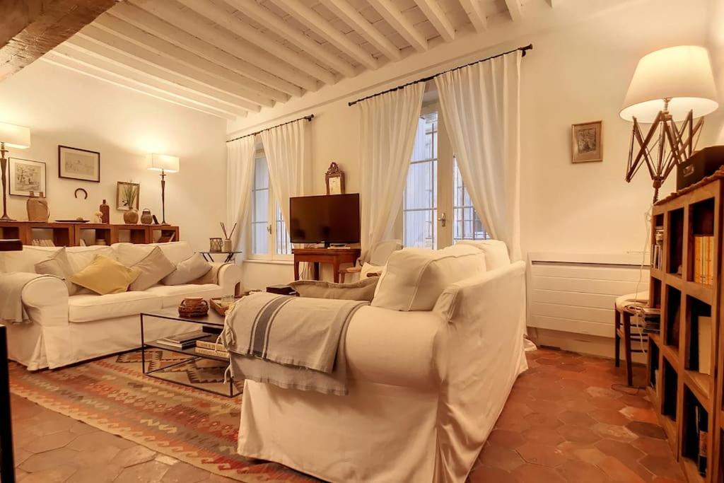 - un salon avec des canapés blancs et une télévision dans l'établissement LE LIMAS - CHARME - WiFI - PATIO - RDC, à Avignon