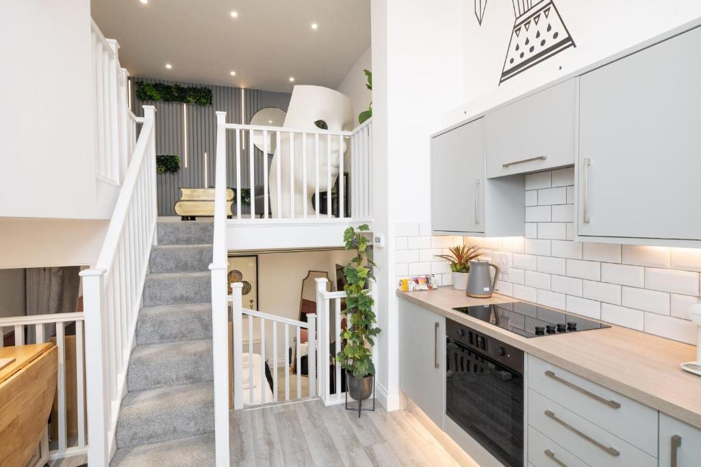 a kitchen with a staircase leading up to a loft at House Of Cards in Royal Tunbridge Wells