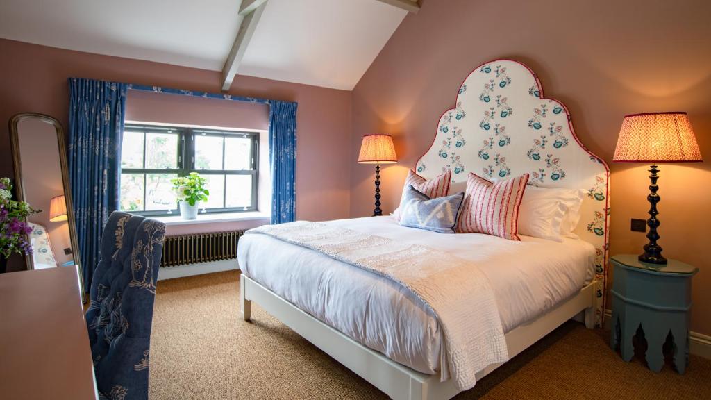 een slaapkamer met een groot bed met een groot hoofdeinde bij The White Lion Cowbridge in Cowbridge