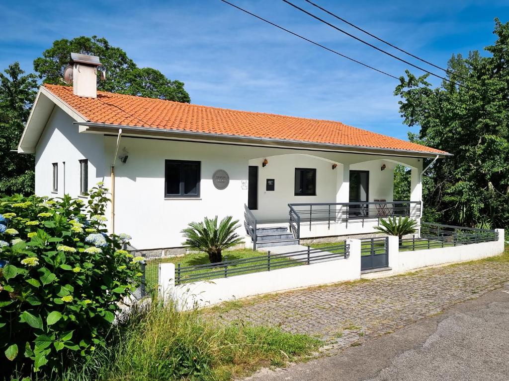 een wit huis met een oranje dak bij Casa Da Ameixieira in Arouca