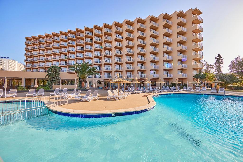 un complexe avec une piscine, des chaises et un hôtel dans l'établissement tent Palmanova, à Palma Nova