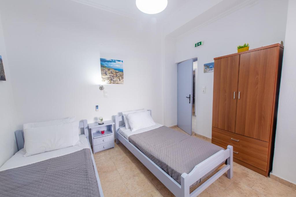 1 dormitorio con 1 cama y armario de madera en SantoriniNY, en Perissa