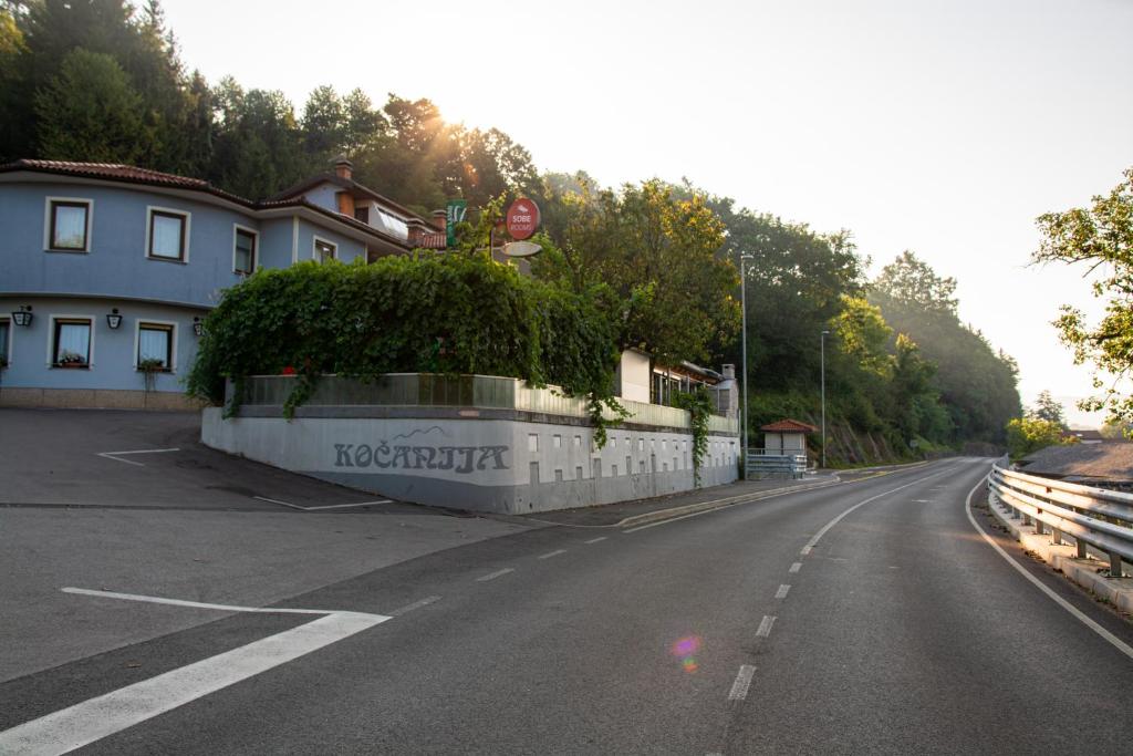 une route vide devant un bâtiment dans l'établissement Guest house Kočanija, à Ilirska Bistrica