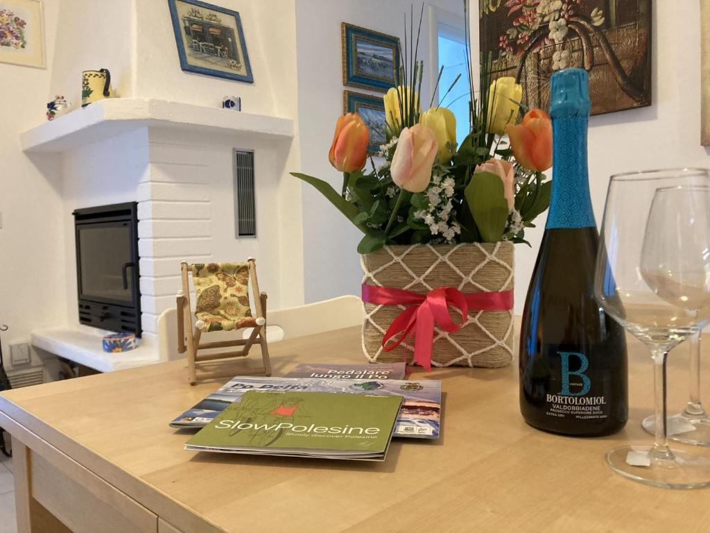 een tafel met een fles wijn en een wijnglas bij Romea in Rosolina Mare