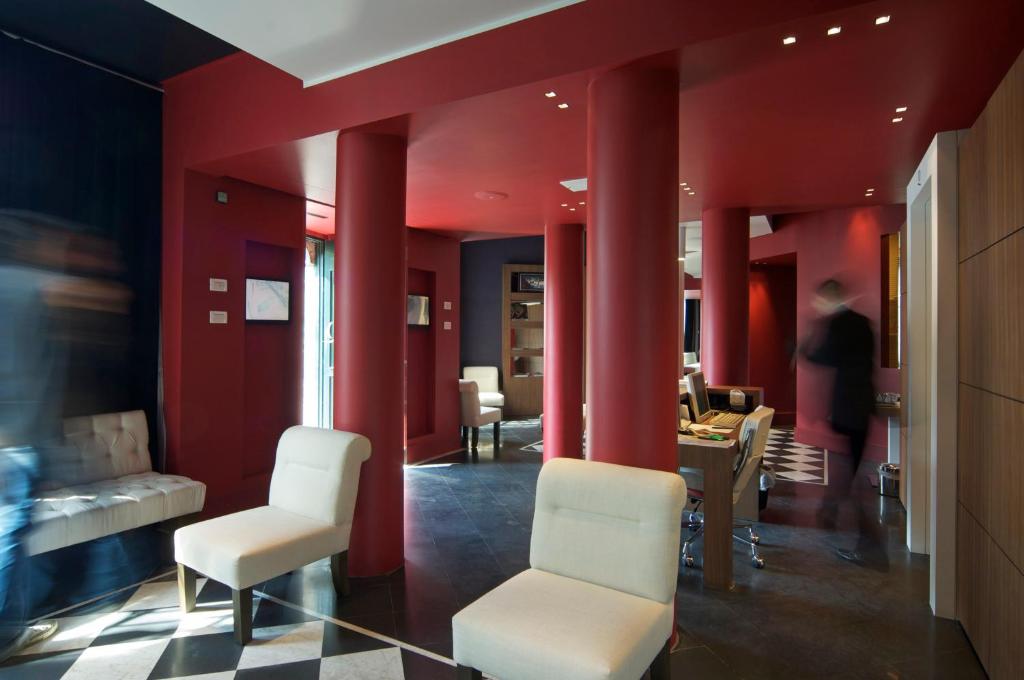 a waiting room with red walls and white chairs at Hotel Piccolo Portofino in Portofino