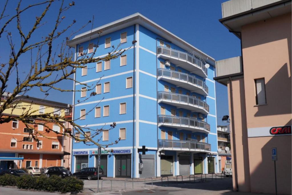 um edifício azul com varandas ao lado em Settimo cielo em Rosolina Mare