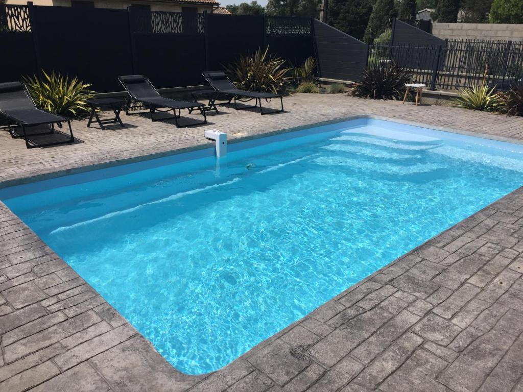 une piscine avec de l'eau bleue dans une cour dans l'établissement Villa privative 3 chambres et piscine priv près Carcassonne, à Carcassonne