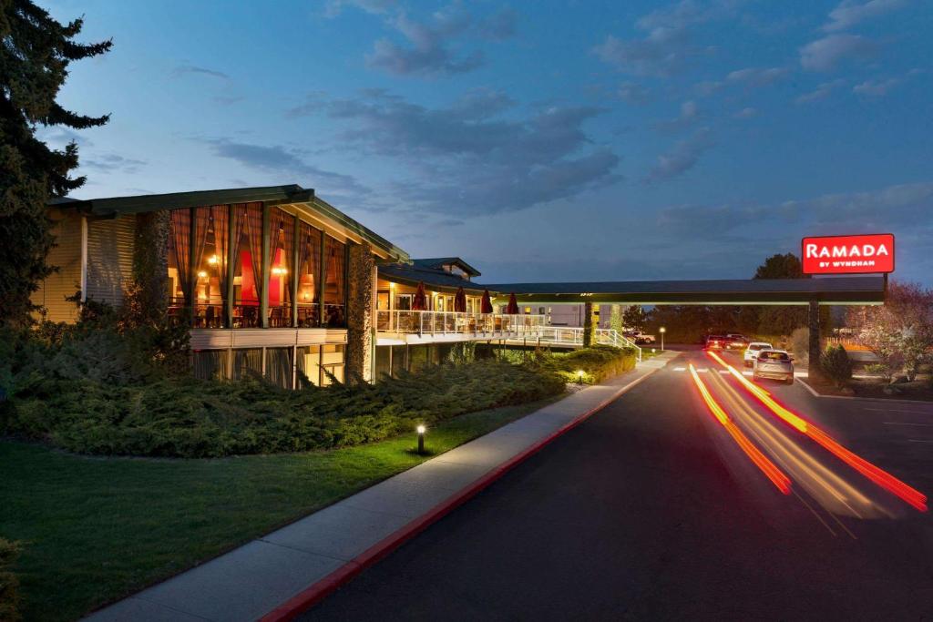 un bâtiment situé sur le côté d'une route la nuit dans l'établissement Ramada by Wyndham Spokane Airport, à Spokane