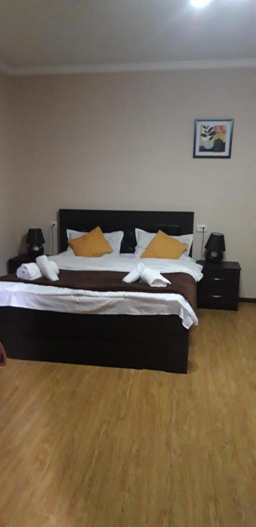 Ira & Vaso's guest house Borjomipark في بورجومي: غرفة نوم بسرير كبير مع مخدات صفراء