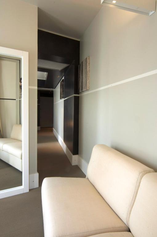 a living room with a couch and a mirror at Hotel Piccolo Portofino in Portofino