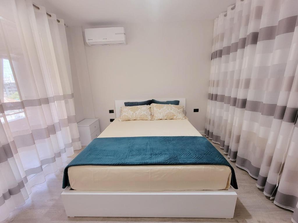 een slaapkamer met een groot bed met gordijnen bij Small Studio near the Olimpik Park in Tirana