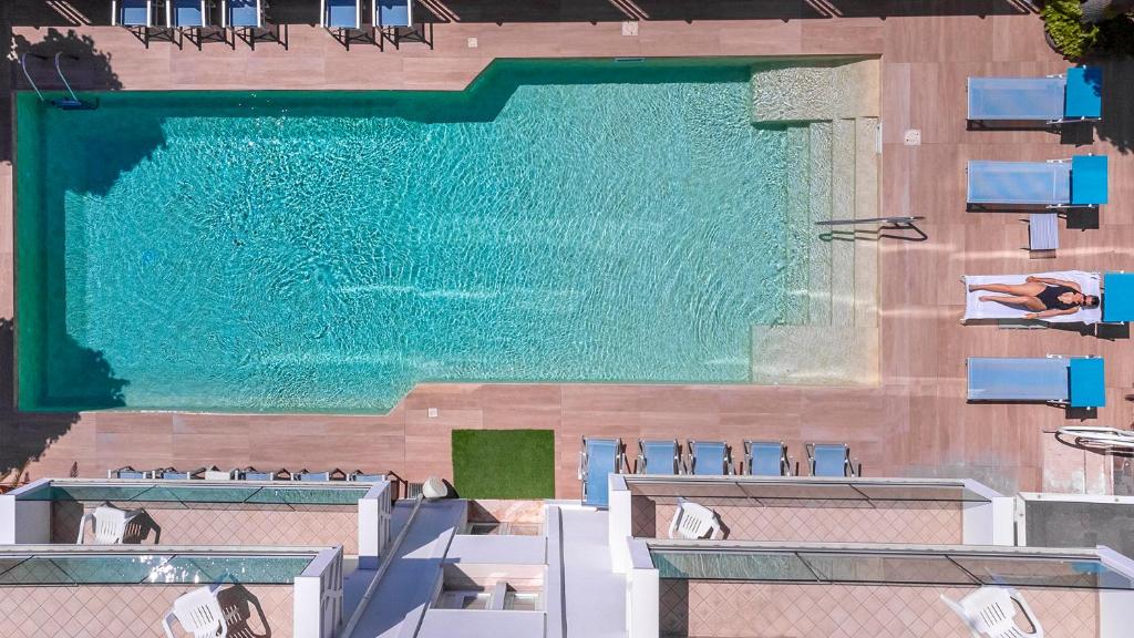 Hotel Rondinella e Viola في ريميني: اطلالة علوية على مسبح مع كراسي