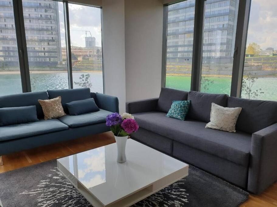 a living room with a blue couch and a table at Amazing Apartment in a vibrant Area with Stunning Lake View in Istanbul! in Esenyurt