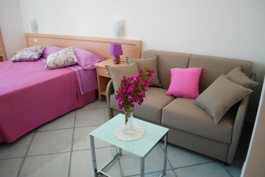 a living room with a couch and a table with flowers at La Vispa Teresa in Ischia