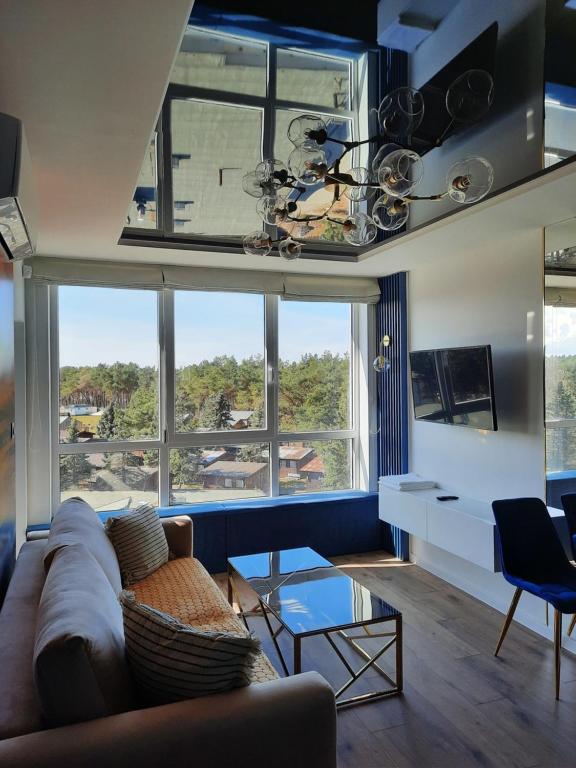 a living room with a couch and a large window at Nadmorski Bursztyn in Rowy