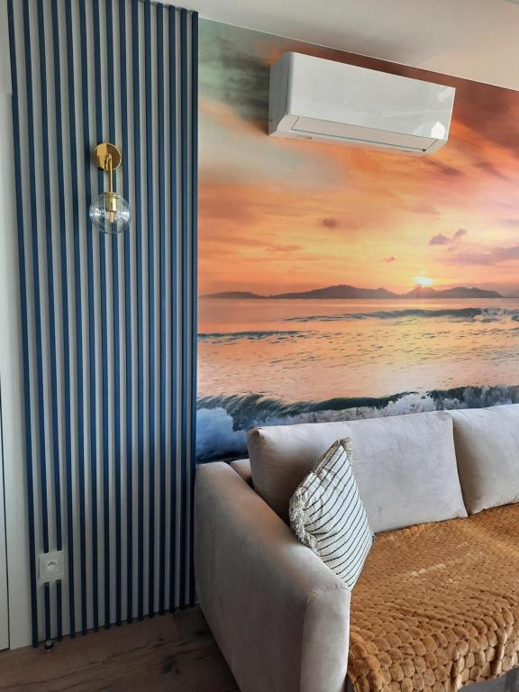 a couch in a room with a painting of the ocean at Nadmorski Bursztyn in Rowy