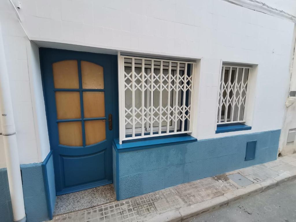 uma porta azul e janela num edifício branco em Mediterrani Haus em L'Ametlla de Mar