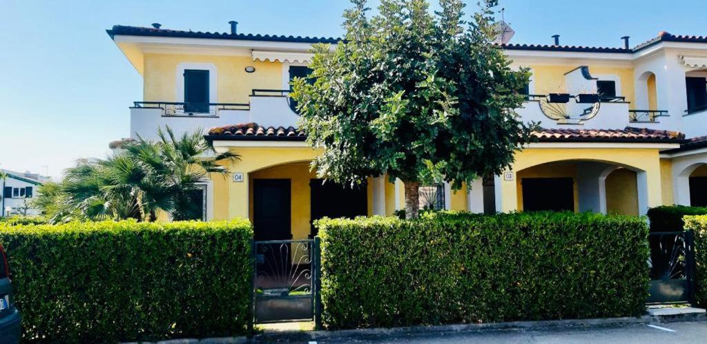 a yellow house with bushes in front of it at Villa Claudia a 400m dal mare in Porto Recanati
