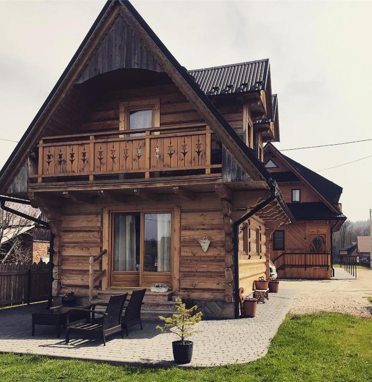 a log cabin with a porch and a balcony at Domek Regionalny Bąkowo Chatka in Witów