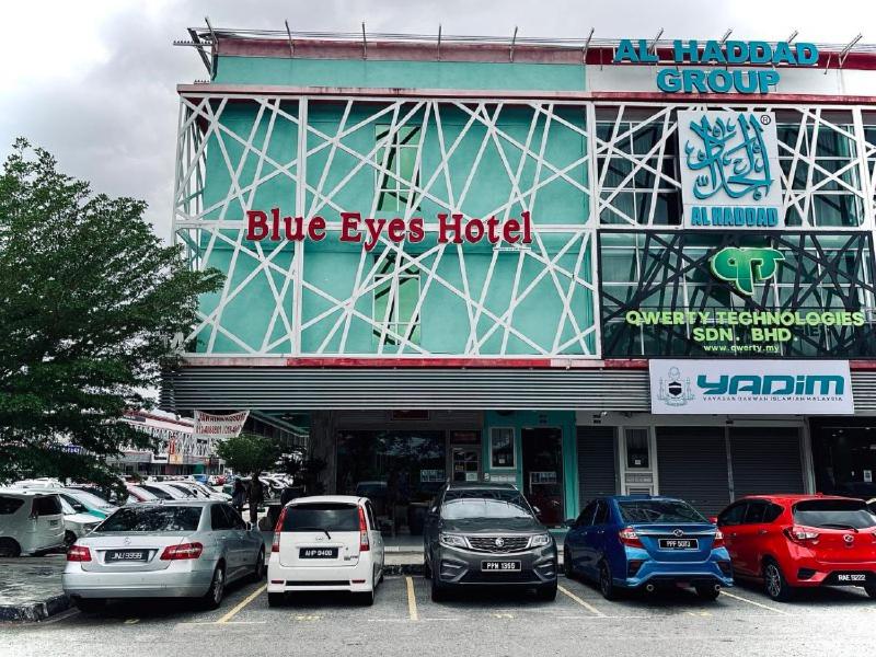 a blue eyes hotel with cars parked in a parking lot at Blue Eyes Hotel in Kepala Batas