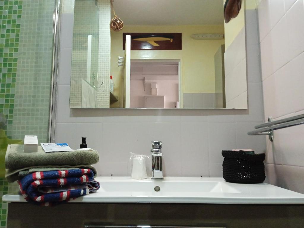 a bathroom sink with a mirror and towels on it at Studio proche gare centre ville in Pau