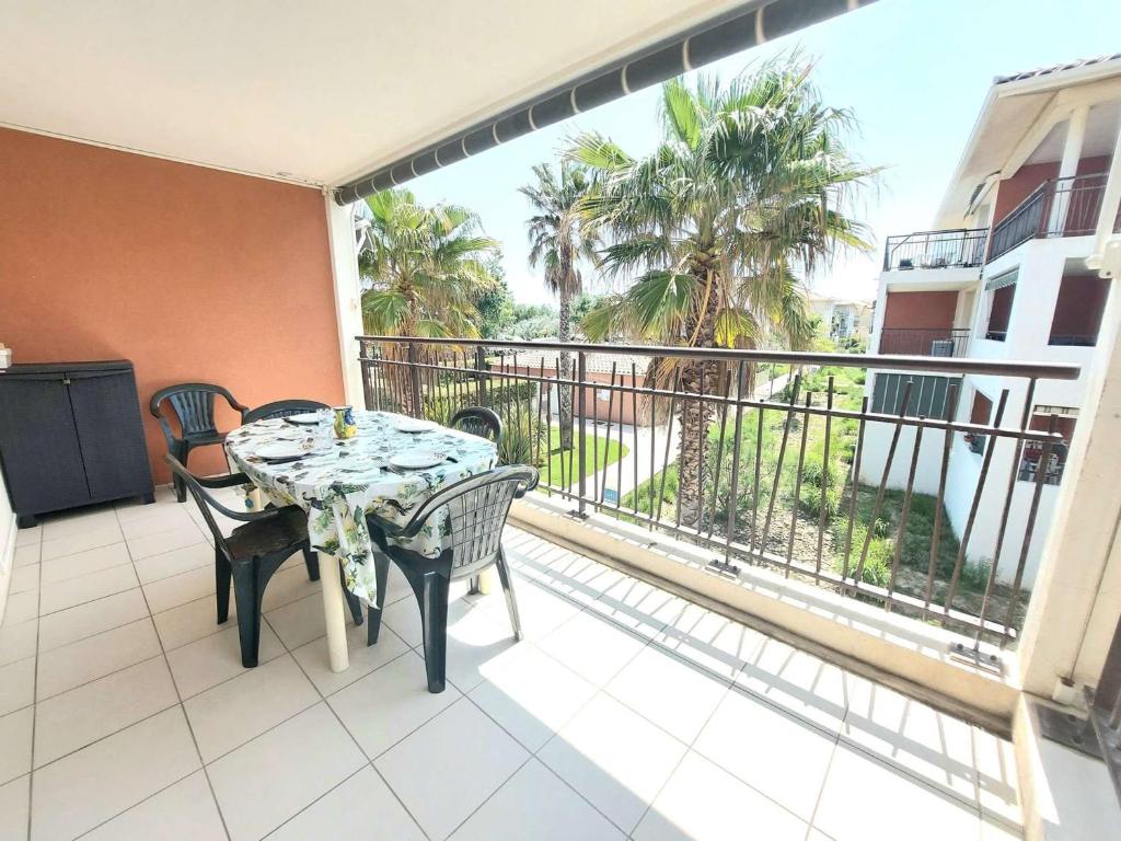 un balcon avec une table et des chaises sur un balcon dans l'établissement Appartement avec Terrasse, Accès Direct Plage et Piscine à Marseillan - FR-1-326-762, à Marseillan