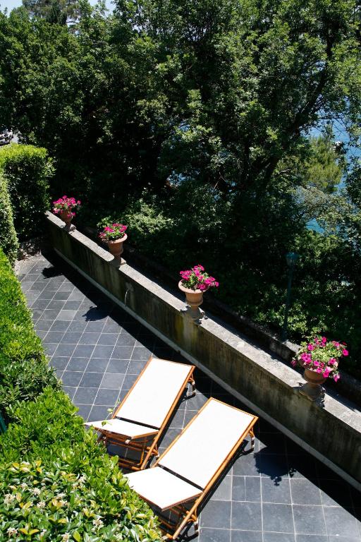 a group of chairs and flowers on a patio at Hotel Piccolo Portofino in Portofino