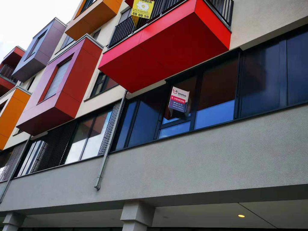 un bâtiment avec des fenêtres colorées et un panneau sur celui-ci dans l'établissement Luxembourg 2 bedroom apartment in Gasperich, à Luxembourg