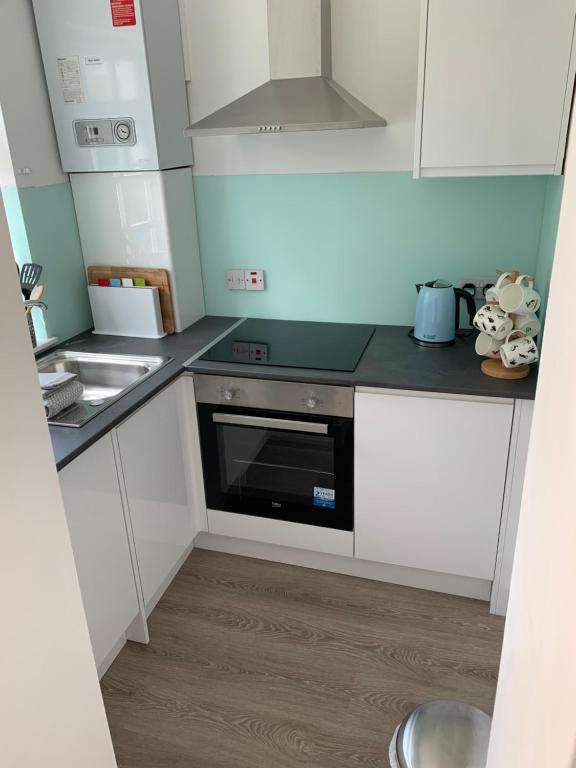 a kitchen with white cabinets and a black oven at Beachside - North Berwick in North Berwick