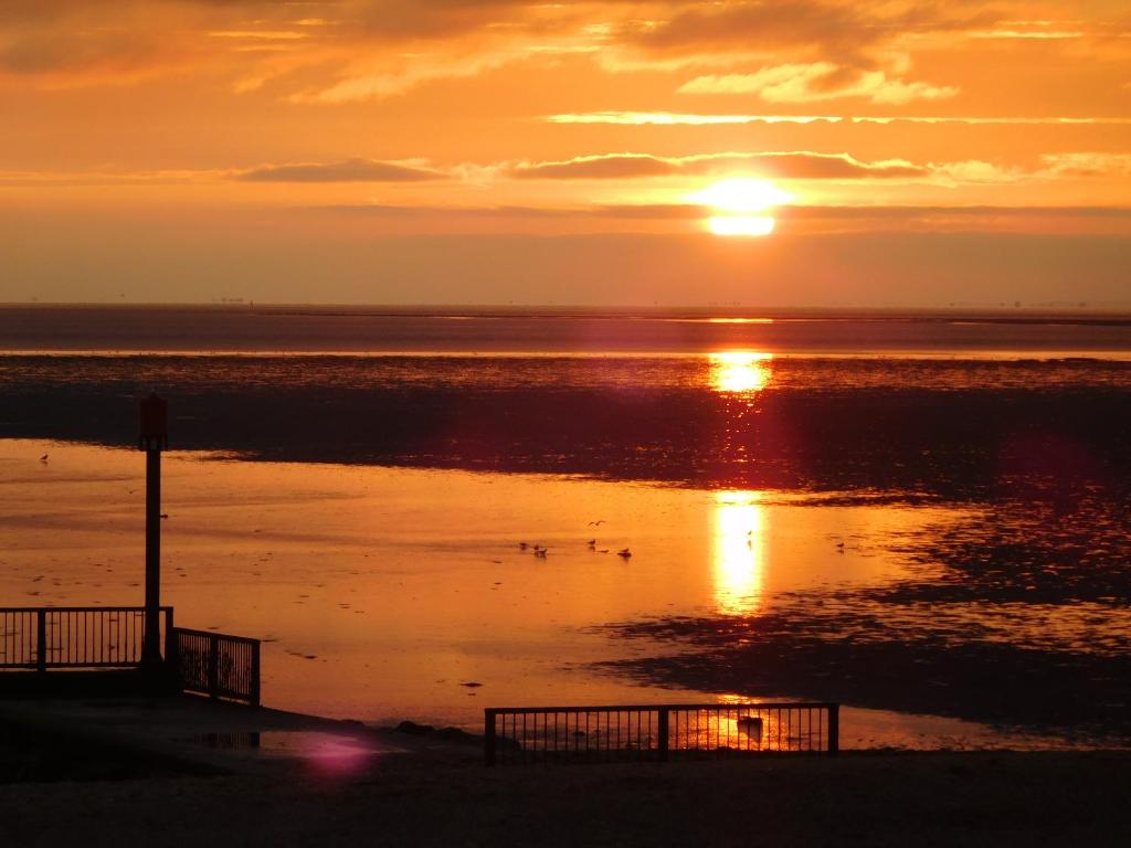 ヒーチャムにあるSunset Beach Retreatの海上のアヒルとともに海上の夕日