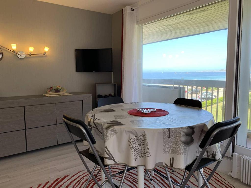 une salle à manger avec une table et une grande fenêtre dans l'établissement Appartement avec WIFI et balcon à Perros-Guirec - FR-1-368-345, à Perros-Guirec