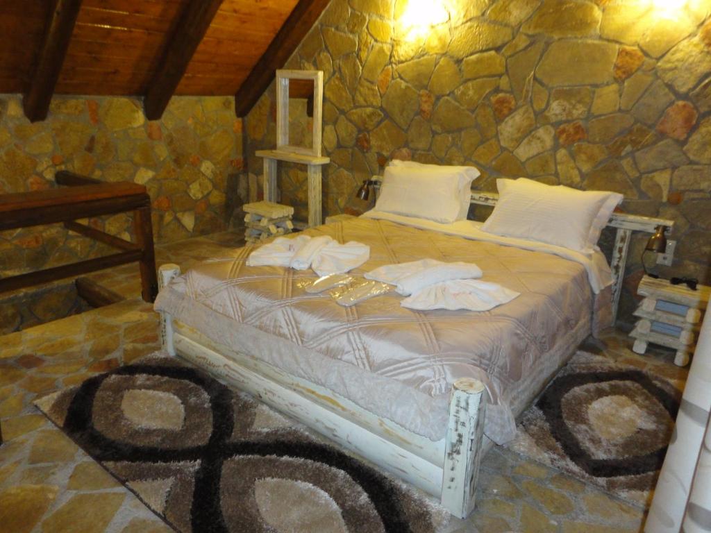 a bedroom with a bed in a stone wall at eco oneiro resort in Kalavrita