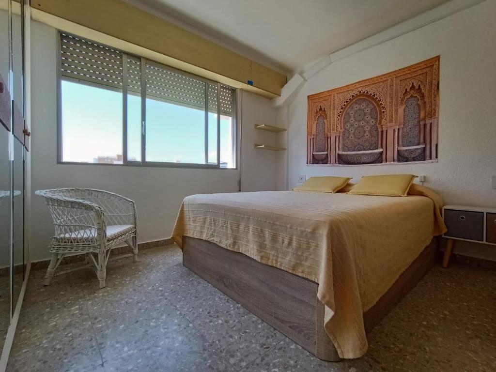 um quarto com uma cama, uma cadeira e uma janela em FIRST LINE SEASIDE - 1 Bedroom BENICASSIM TORREON em Benicàssim