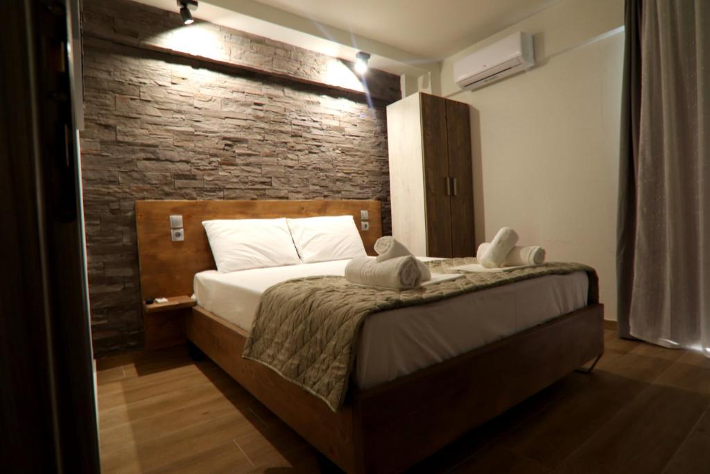a bedroom with a bed with a brick wall at LDG Rooms in Olympic Beach