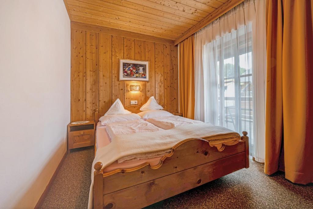 ein Schlafzimmer mit einem Bett und einem großen Fenster in der Unterkunft Apartment Schwalbennest in Mühlbach