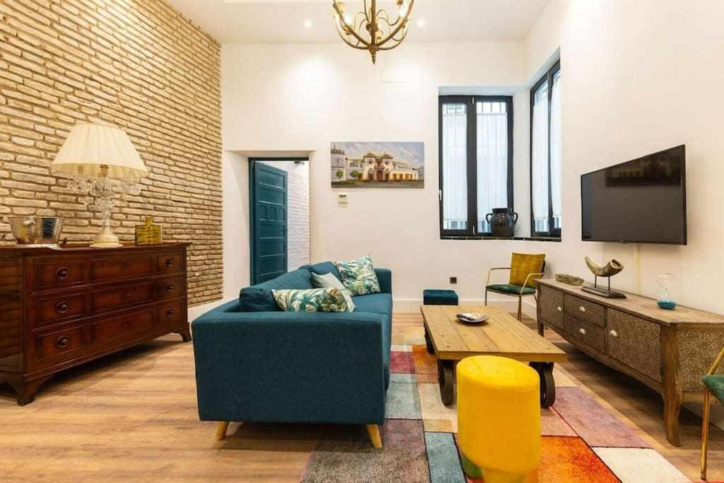 sala de estar con sofá azul y mesa en MonKeys Apartments Betis Chill Out, en Sevilla