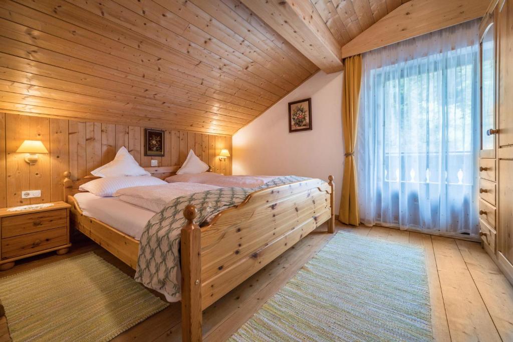 - une chambre avec un lit et un plafond en bois dans l'établissement Apartment Waldesruh, à Rio di Pusteria