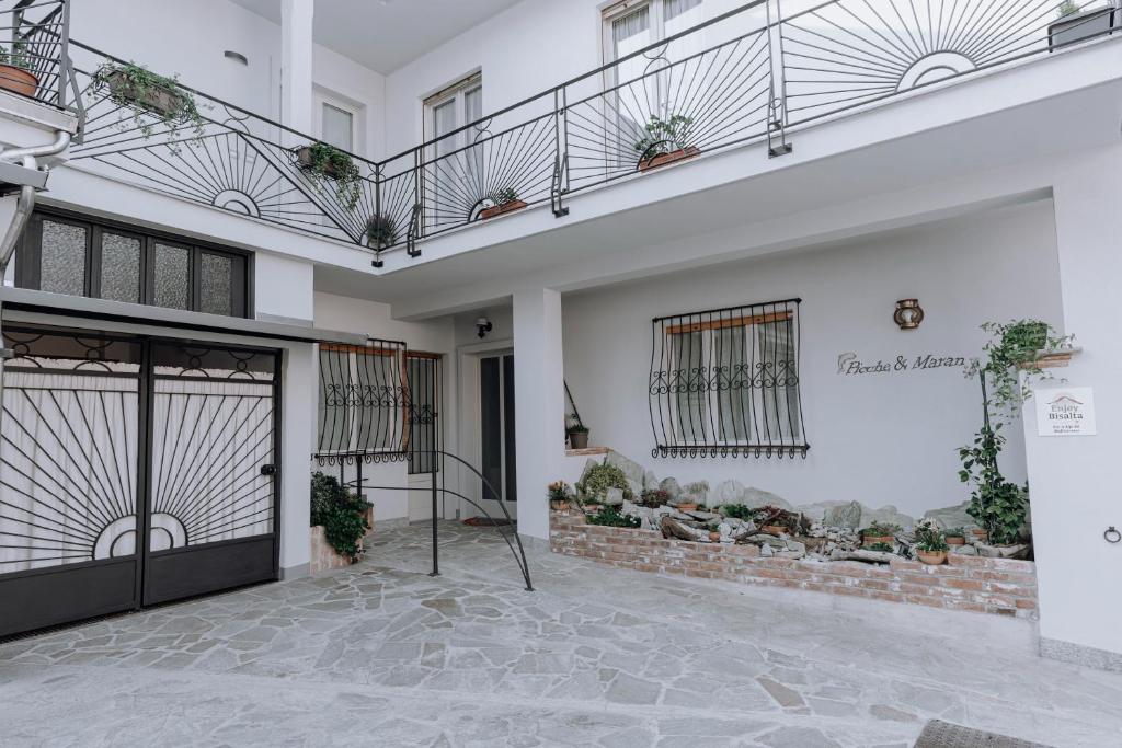 um edifício branco com uma porta e uma varanda em Appartamento Maran em Peveragno