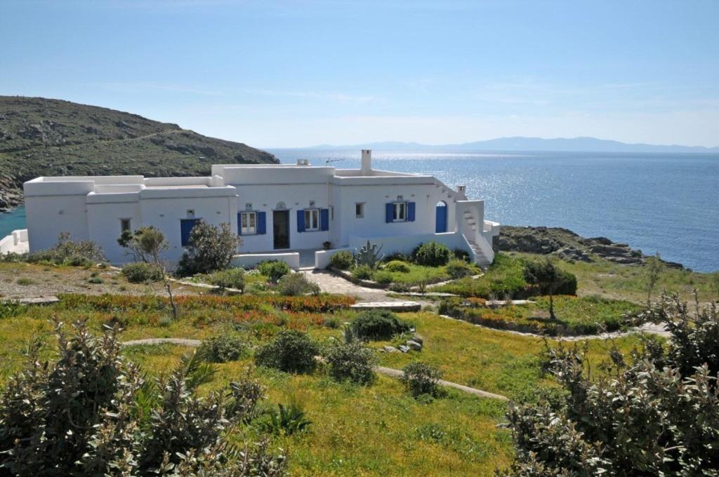 una casa blanca en una colina junto al océano en Villa Areti, en Tinos