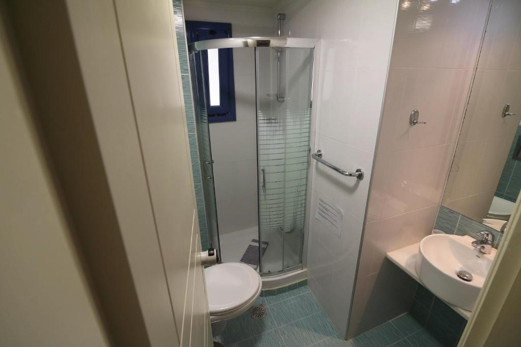 a bathroom with a shower and a toilet and a sink at Horizon Beach Hotel in Plakias