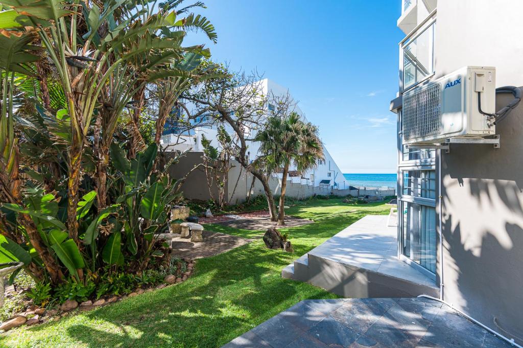 a view of a yard with palm trees and the ocean at Casablanca 6 in Ballito