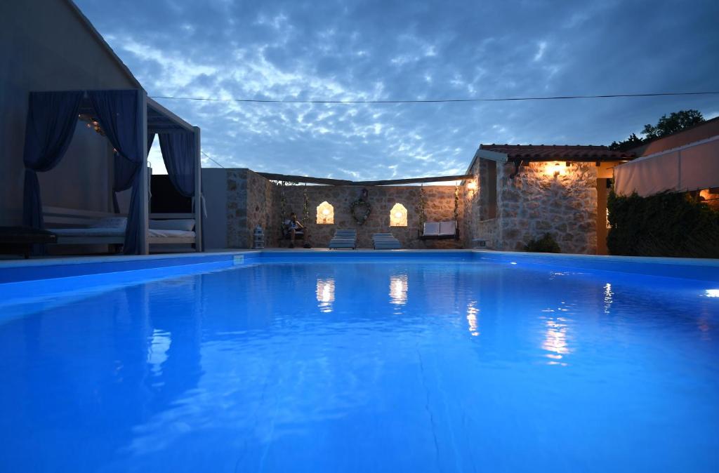 a large swimming pool with blue lighting in a house at Villa ANTONA in Prkos