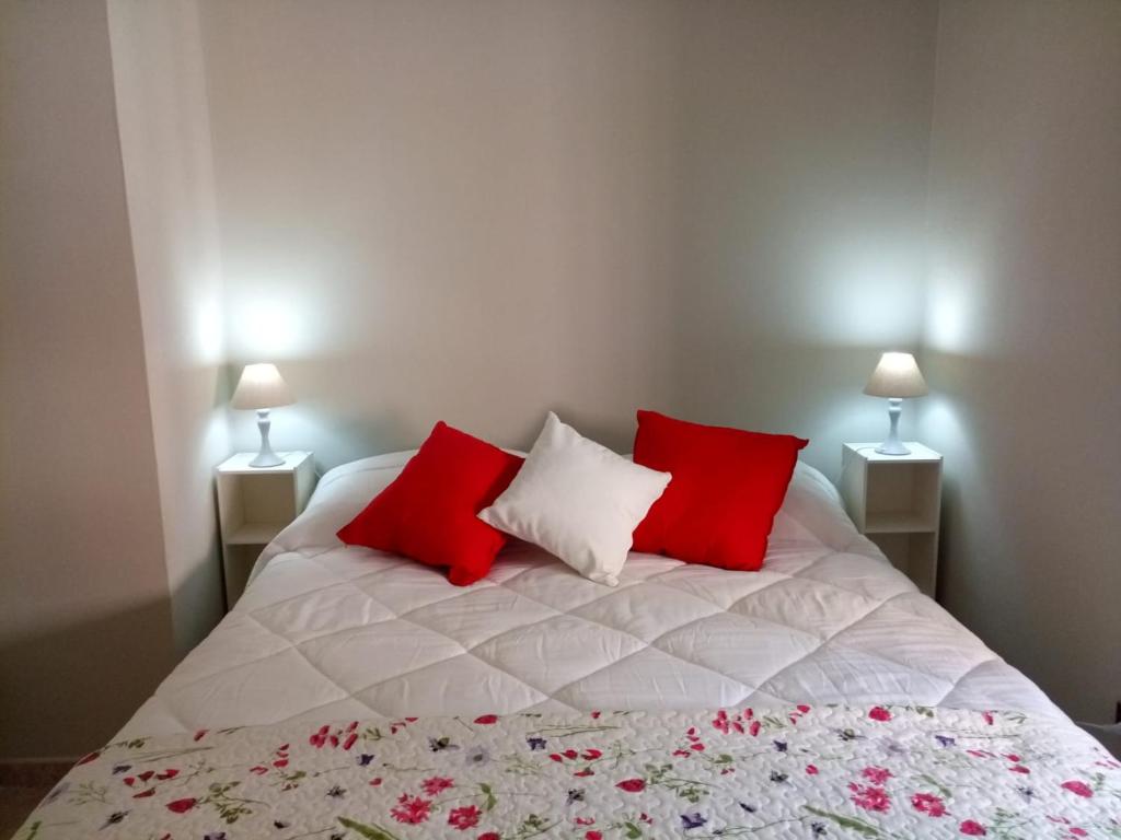 1 dormitorio con 1 cama con almohadas rojas y blancas en La Casa di Tagliacozzo delizioso appartamento centrale con 2 camere e camino en Tagliacozzo
