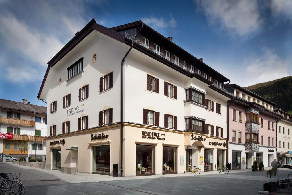 ein großes weißes Gebäude mit Fenstern auf einer Straße in der Unterkunft Residence Innichen - San Candido in Innichen