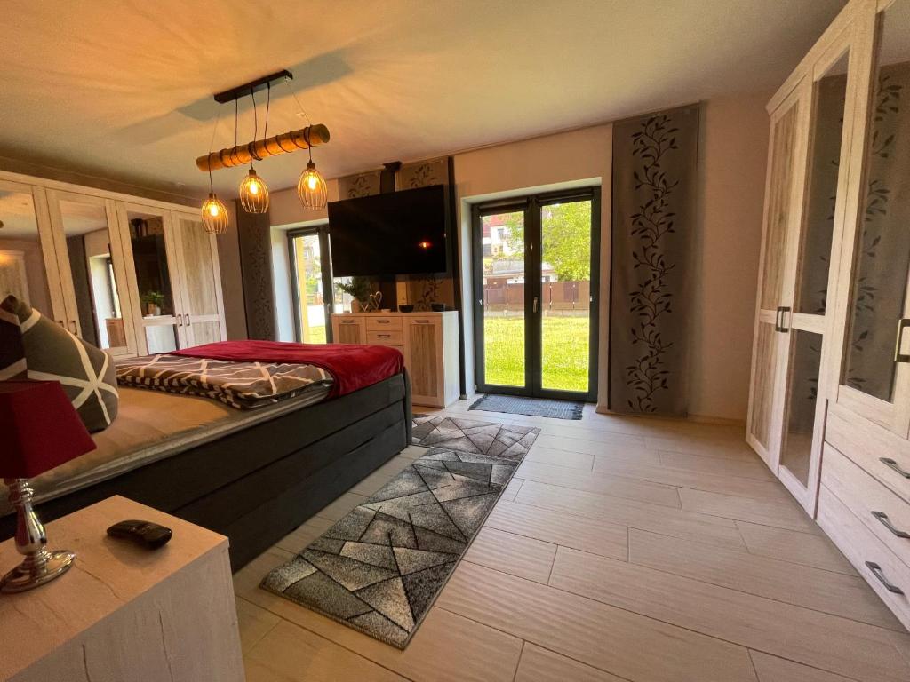 ein Schlafzimmer mit einem Bett und einem TV in einem Zimmer in der Unterkunft Ferienhaus Nicole II, Barrierefrei, mit HIRO Lift in Quedlinburg