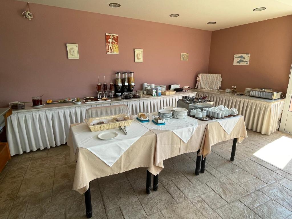 a room with two tables with white table cloths at Horizon Beach Hotel in Plakias
