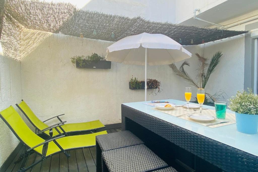 a table with a yellow chair and an umbrella at La Perle Marine 3 in Le Grau-du-Roi