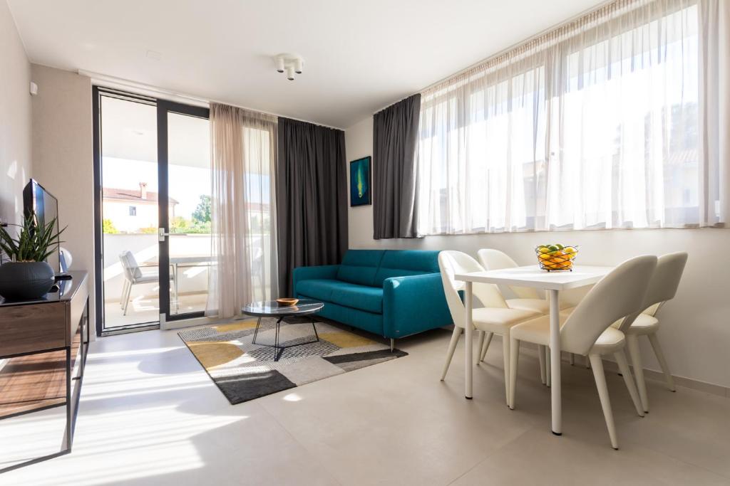 a living room with a table and a blue couch at Villa Piano Residences in Vantačići