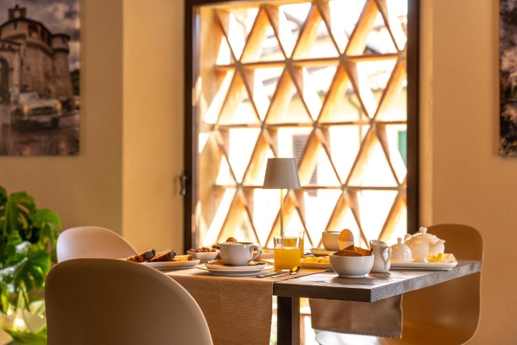 stół z talerzami i oknem w obiekcie Il Pradicciolo Agriturismo w mieście Castelnuovo di Garfagnana